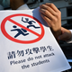 Students in the Mid-Levels area hold a sign modeled on signs used in Hong Kong’s subway system as part of a human-chain protest.